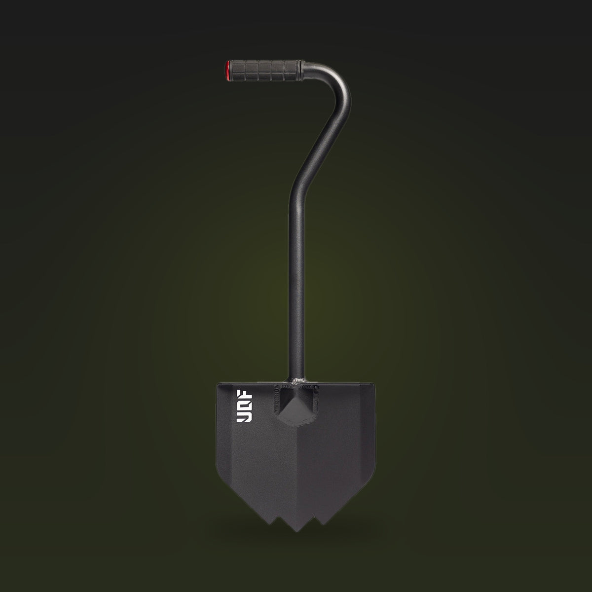 Black overland shovel with a pointed blade, bent handle and rubber grip, on a dark olive background