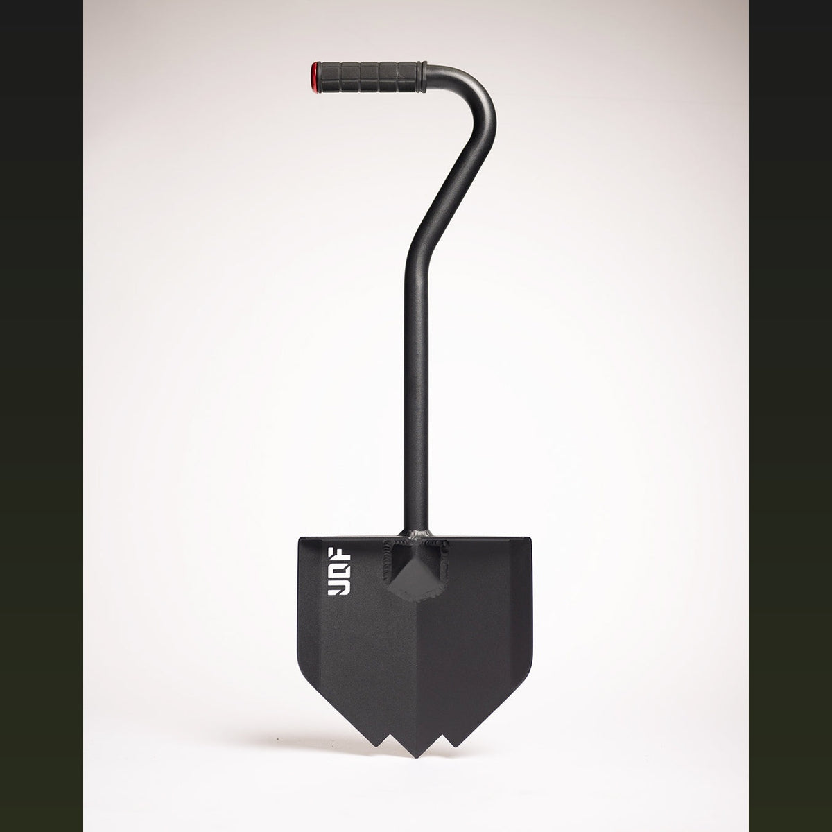 Black overland shovel with a pointed blade, bent handle and rubber grip, on a white background